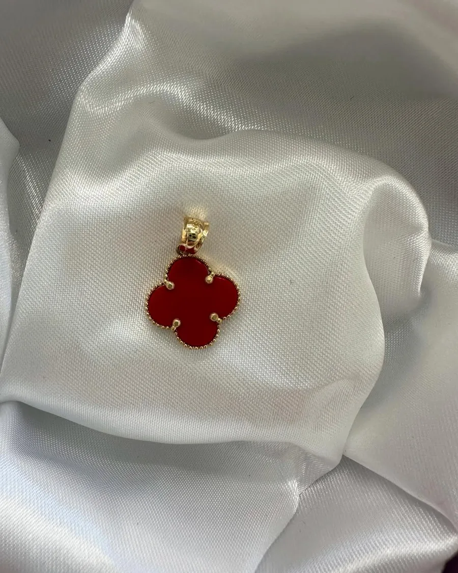 Gold pendant with a red four-leaf clover